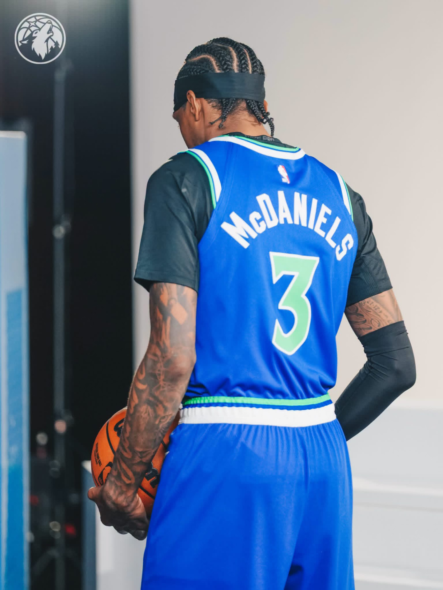 Jaden McDaniels from behind showing McDANIELS #3 on his blue Wolves jersey, ball tucked at his hip